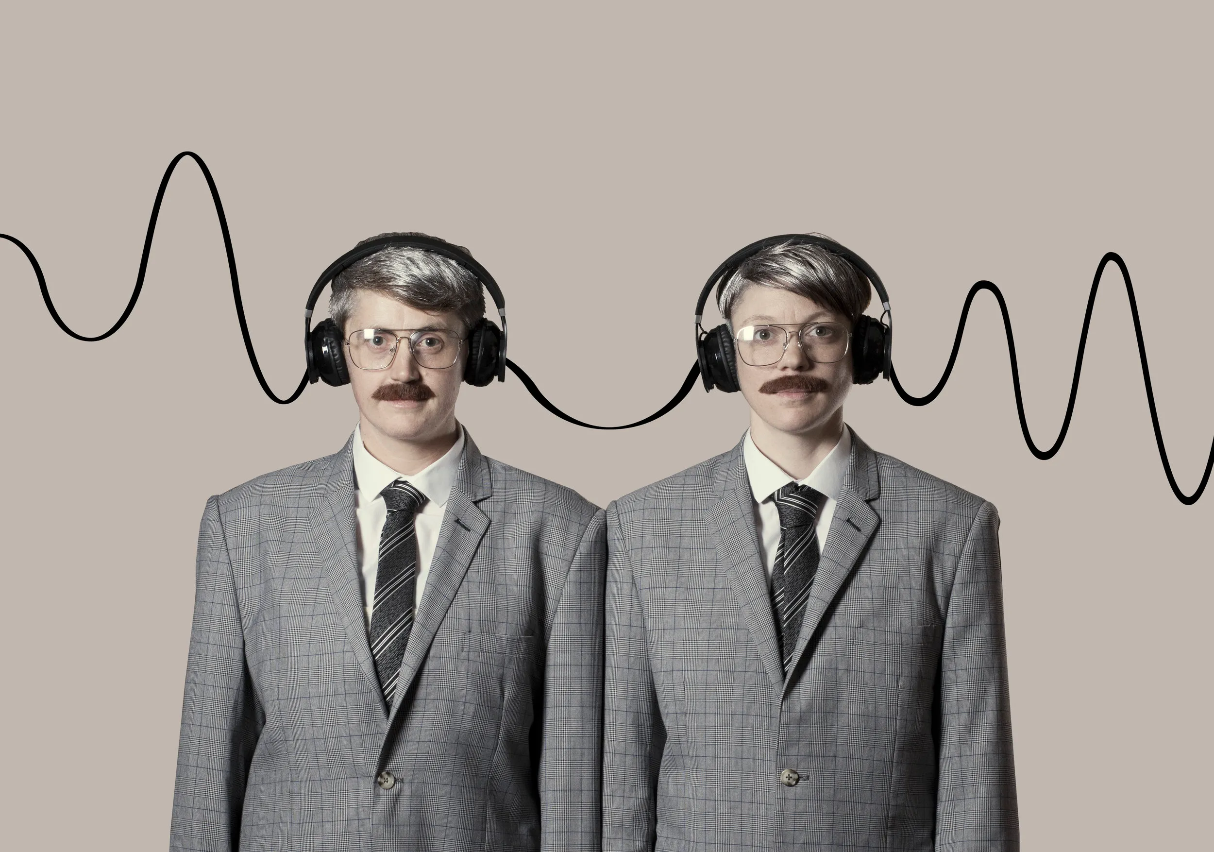 Rosana Cade and Ivor MacAskill as identical DJs Barry and Barry, in grey check suits, glasses, moustaches and headphones joined by a wavy cable